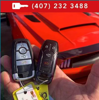 Two car key fobs held in hand with red sports car in background and phone number displayed at top